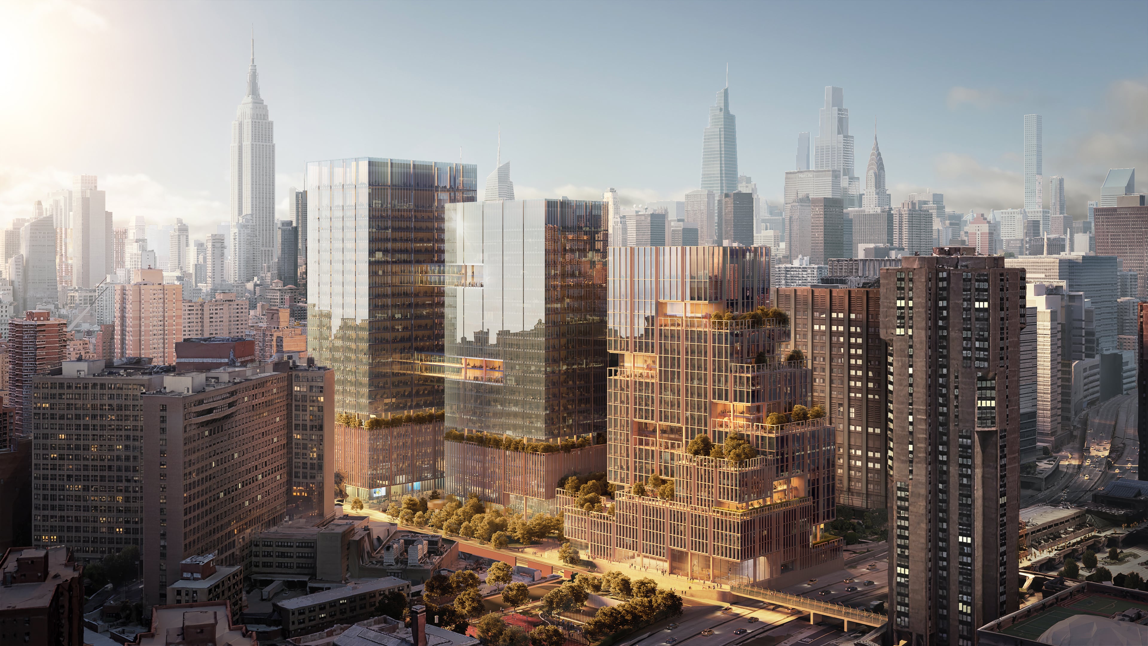 Rendering of SPARC Kips Bay. Aerial view of New York City featuring several high-rise glass buildings. The sun casts a warm glow, reflecting off the structures. In the background, a skyline of taller skyscrapers is visible against a hazy sky.