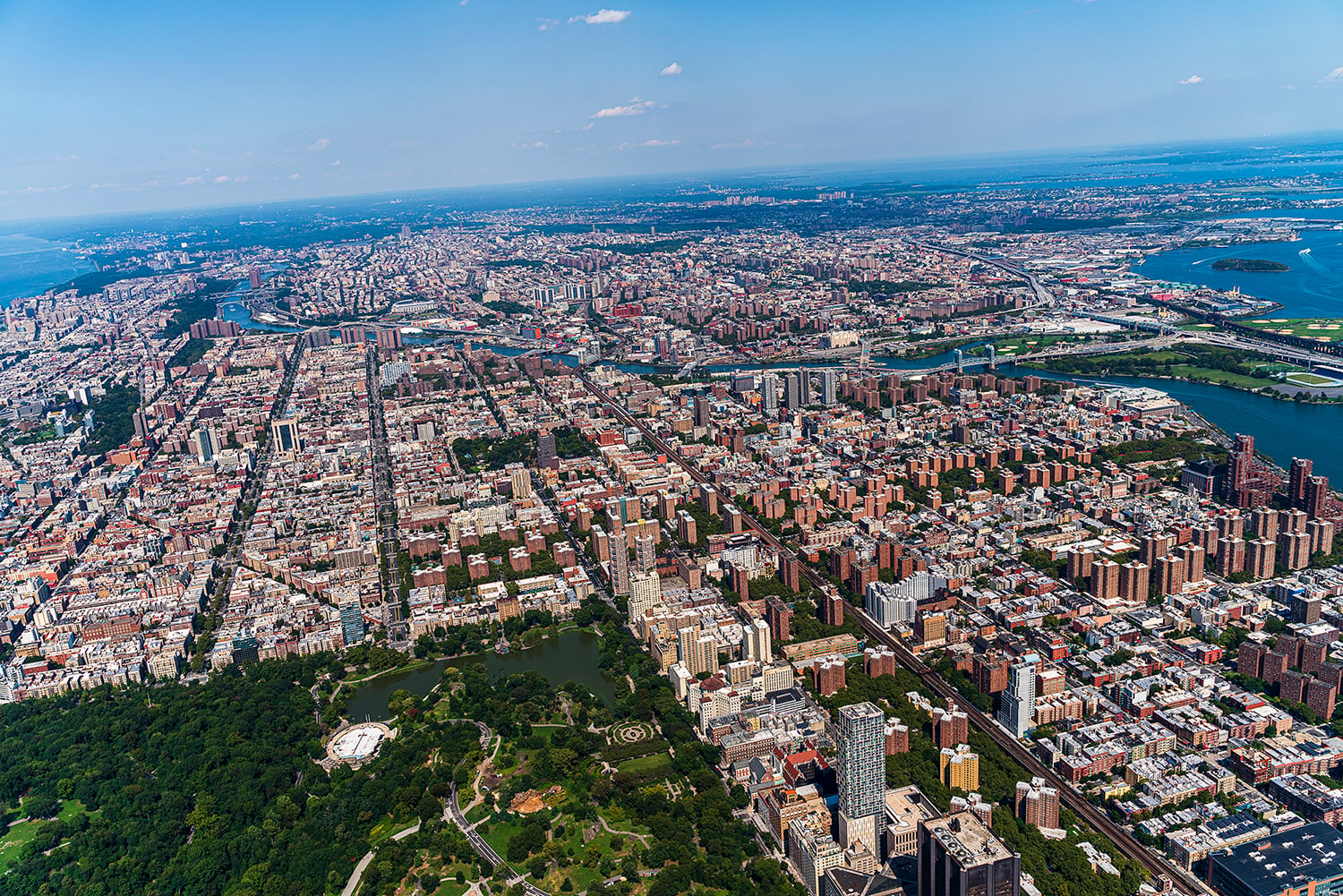 Aerial view of Central Park, Manhattan, and Harlem, and The Bronx in a distance behind, from a helicopter on a sunny summer day.