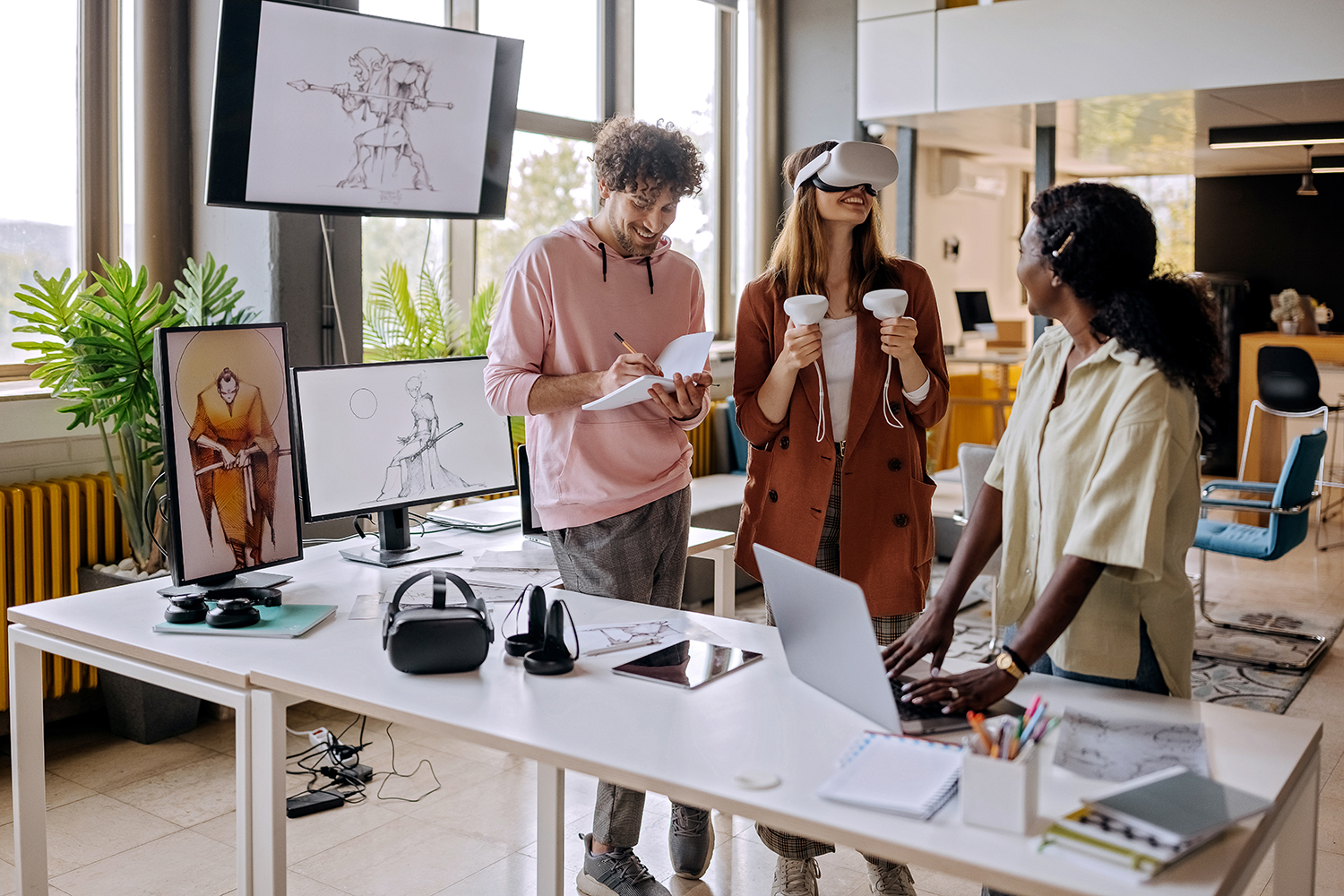 Group of gaming VR developers testing their new software in the office together.