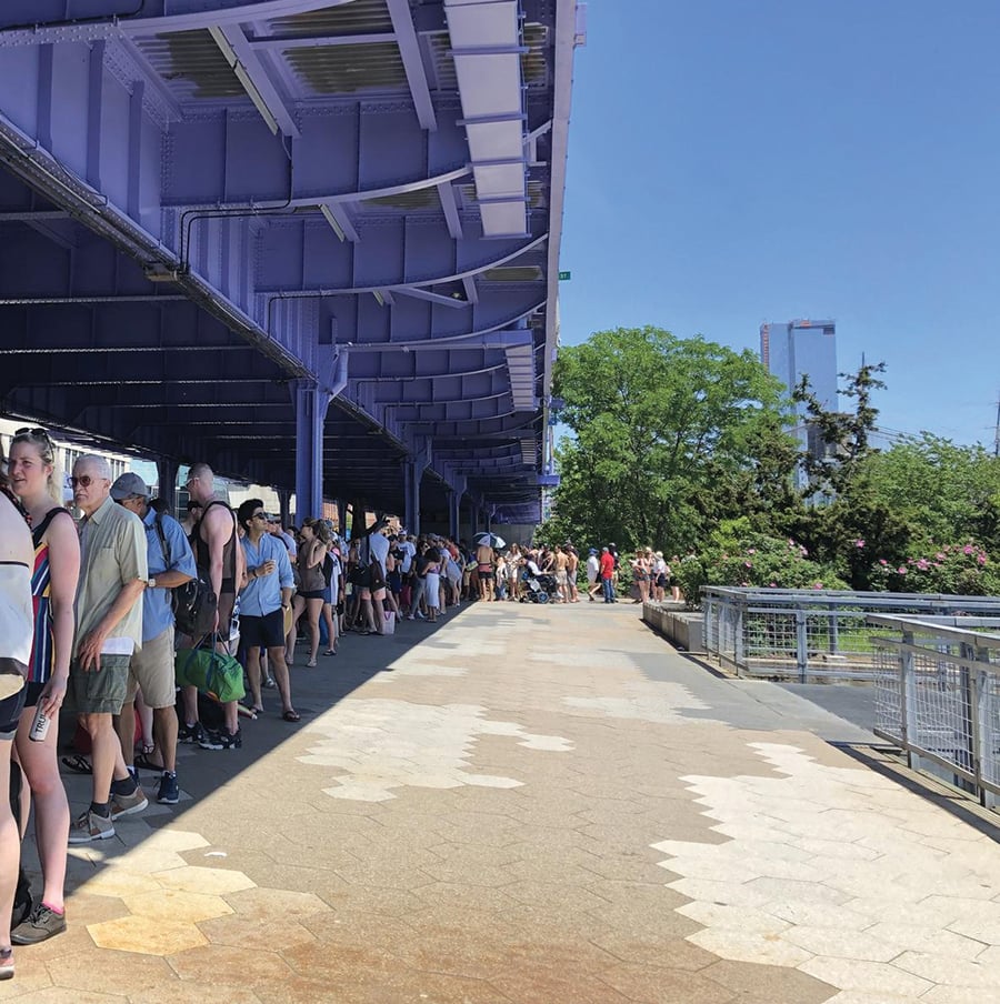 Aerial view of Whitehall Ferry Terminal, including the Staten Island Ferry, the Battery Maritime Building, and Governors Island Ferry. Ferries docked by the waterfront, next to tall office buildings and a nearby park with trees and pathways.
