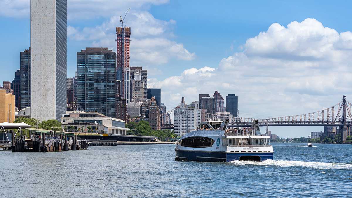 View from the East River Esplanade near Stuyvesant Cove featuring a ferry boat with the United Nations Building in the background. 