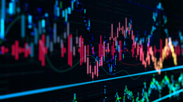 A digital display of a financial market chart shows various lines and colored bars, representing fluctuating stock or currency data on a black background. Bright colors such as red, blue, and green indicate different market activities and trends.