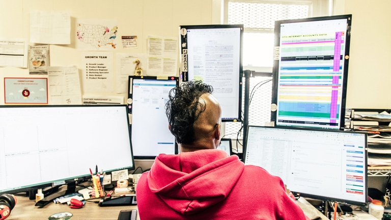 Worker in front of a group of computer monitors