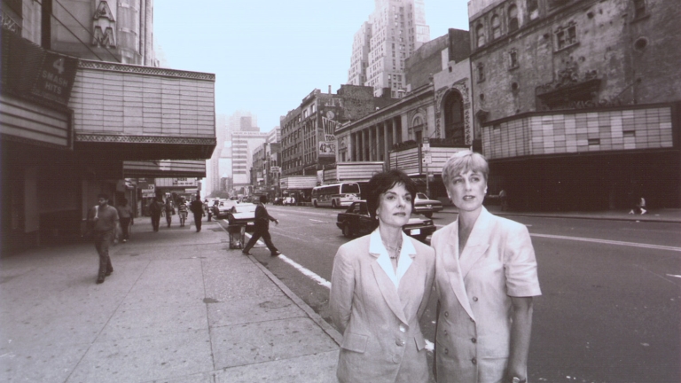 Rebecca Robertson (right) and Cora Cahan (left) stand with the empty theatres and stores of 42nd Street in the background. Credit: New York Times