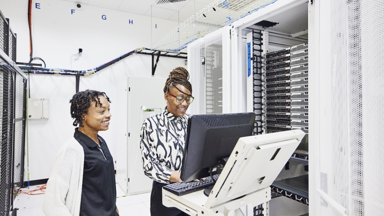 IT professionals in discussion while configuring server in data center IT professionals in discussion while configuring server in data center