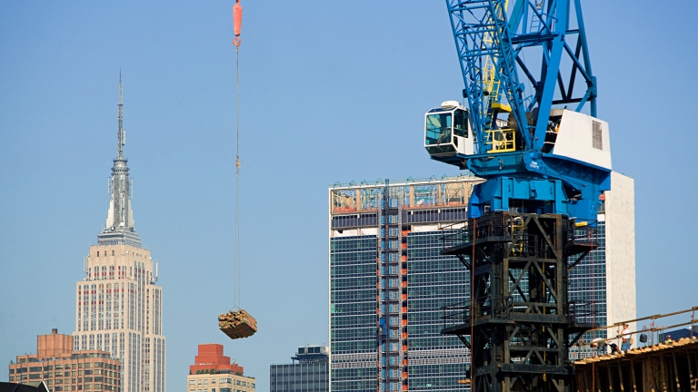 Crane lifting construction material over New York 
