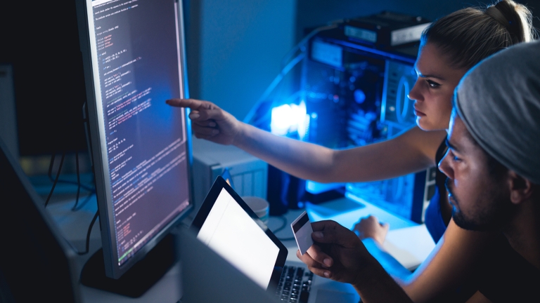 Cybersecurity colleagues working at a computer Cybersecurity colleagues working at a computer