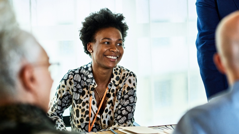 Mid-adult black businesswoman smiling in meeting