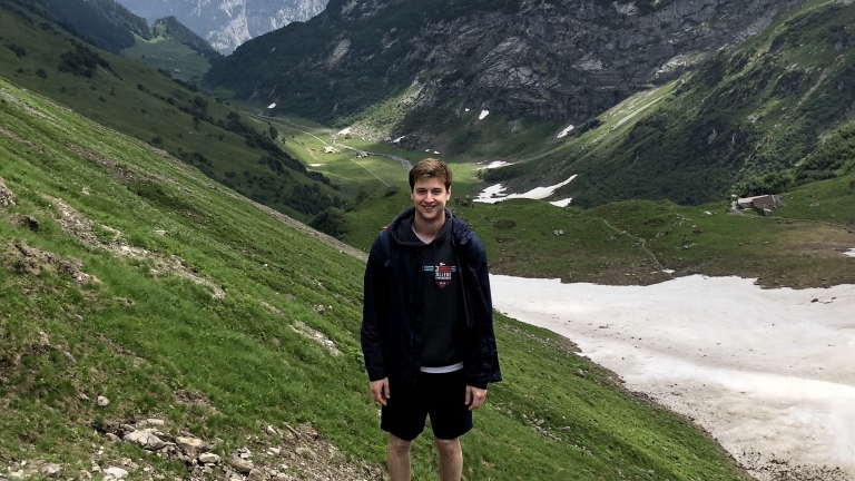 January Employee of the Month, Christopher Carley standing in the front of mountains