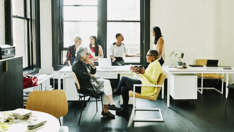 Female coworkers in discussion during team meeting in creative office.