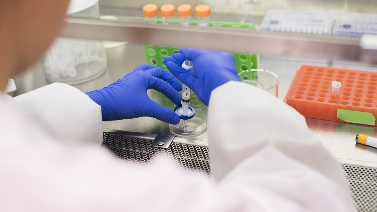 Asian scientist using syringe and petri dish