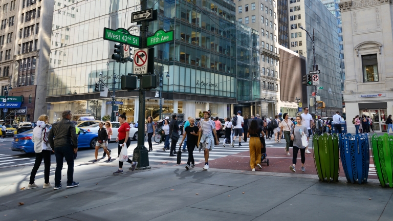 People crossing the intersection of 42nd Street and 5th avenue in Manhattan, NYC.