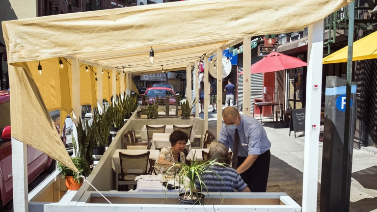 Two people dining in an outdoor shed in New York City.