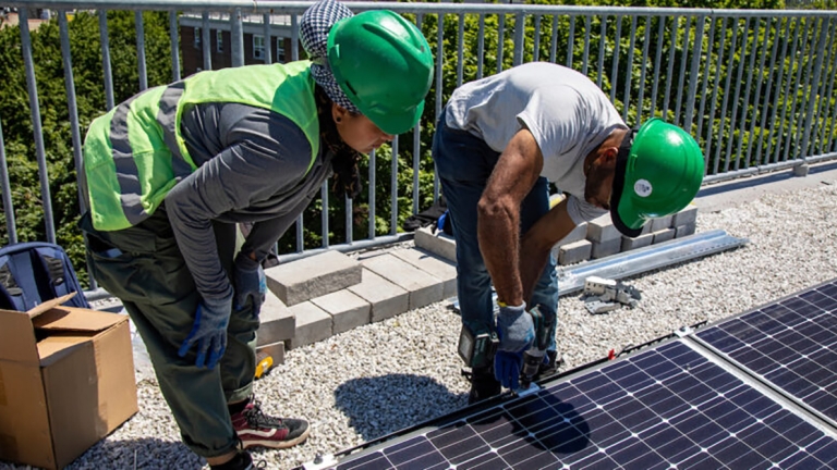 Clean Energy Academy trainee learning solar panel installation.