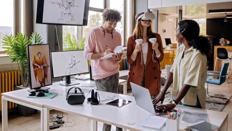 Group of gaming VR developers testing their new software in the office together. Group of gaming VR developers testing their new software in the office together.