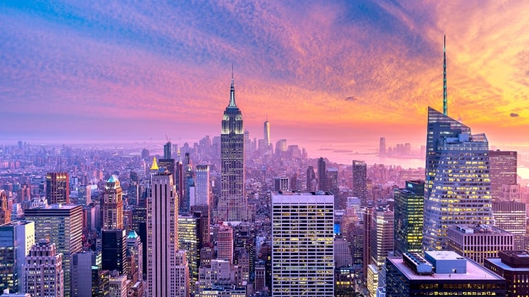Vibrant sunset above the Manhattan Skyline, looking towards the Empire State Building and the World Trade Center in the background. Seen from the Observation Deck of the Rockefeller Center.