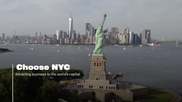 Aerial view of the Statue of Liberty with the Manhattan skyline in the background; text reads Choose NYC: Attracting business to the world’s capital.