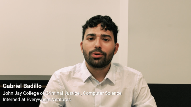 A man with short curly hair and a beard, wearing a white button-up shirt, sits indoors against a plain background. On-screen text reads: Gabriel Badillo, John Jay College of Criminal Justice, Computer Science, Interned at Everywhere Ventures.