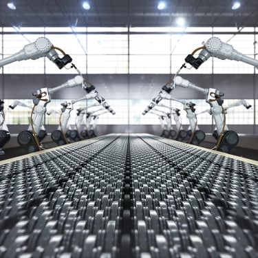 Robotic arm and steel conveyor in assembly manufacturing factory.