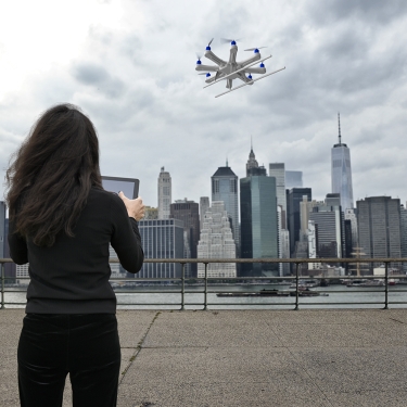 Young women using a drone over the East River in New York City.