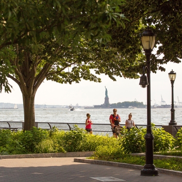 View of the Statue of Liberty and waterfront in Battery Park City in Lower Manhattan. View of the Statue of Liberty and waterfront in Battery Park City in Lower Manhattan.