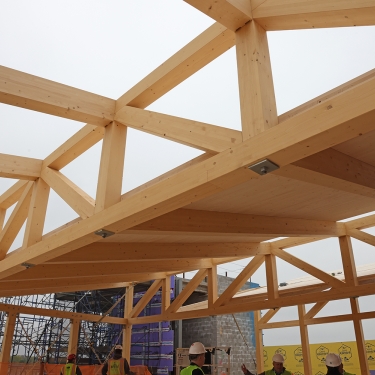 Construction site showing a partially built wooden frame structure Construction site showing a partially built wooden frame structure