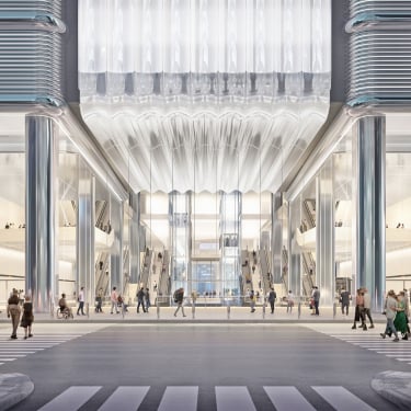 Rendering of Port Authority Bus Terminal featuring a modern, spacious building entrance with high ceilings, large glass panels, shiny metallic columns, and people walking or standing inside. Escalators are visible in the background, and a crosswalk is in the foreground.