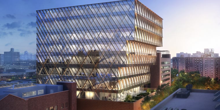 Aerial rendering of Public Health Lab shows a modern glass building with diagonal patterns and multiple terraces, glowing with interior lights at dusk, surrounded by New York City buildings and trees under a partly cloudy sky.
