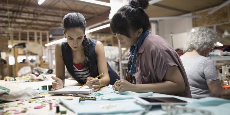 Three fashion designers working at a studio space