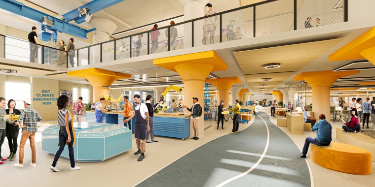 Interior view of Brooklyn Army Terminal, showing a spacious, multi-level indoor innovation hub with people interacting. The area features modern design elements, including yellow pillars, workstations, and a walkway. The atmosphere is lively and collaborative.