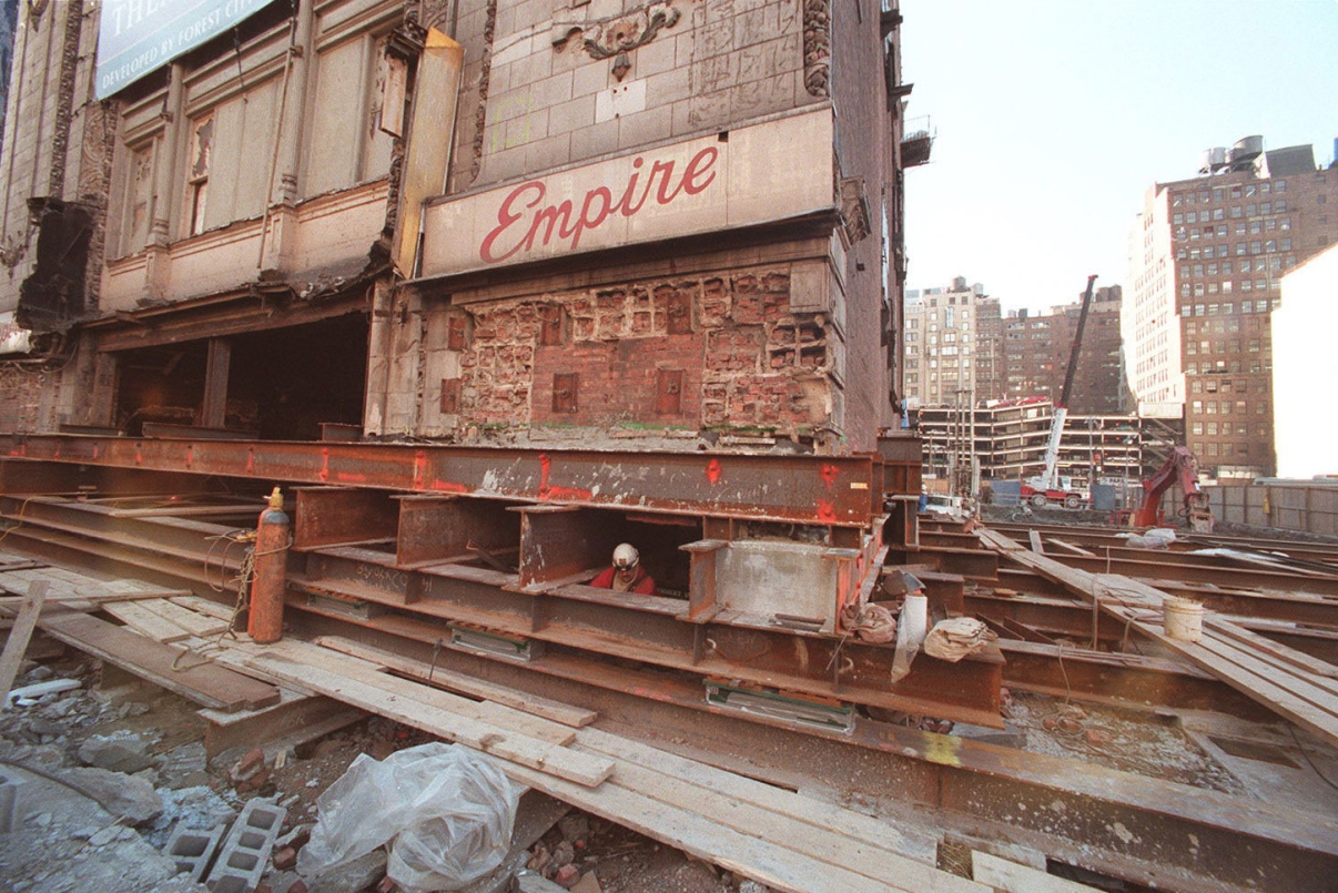 Construction workers putting the Empire Theatre on lifts for its move west. Image: The New York Times.