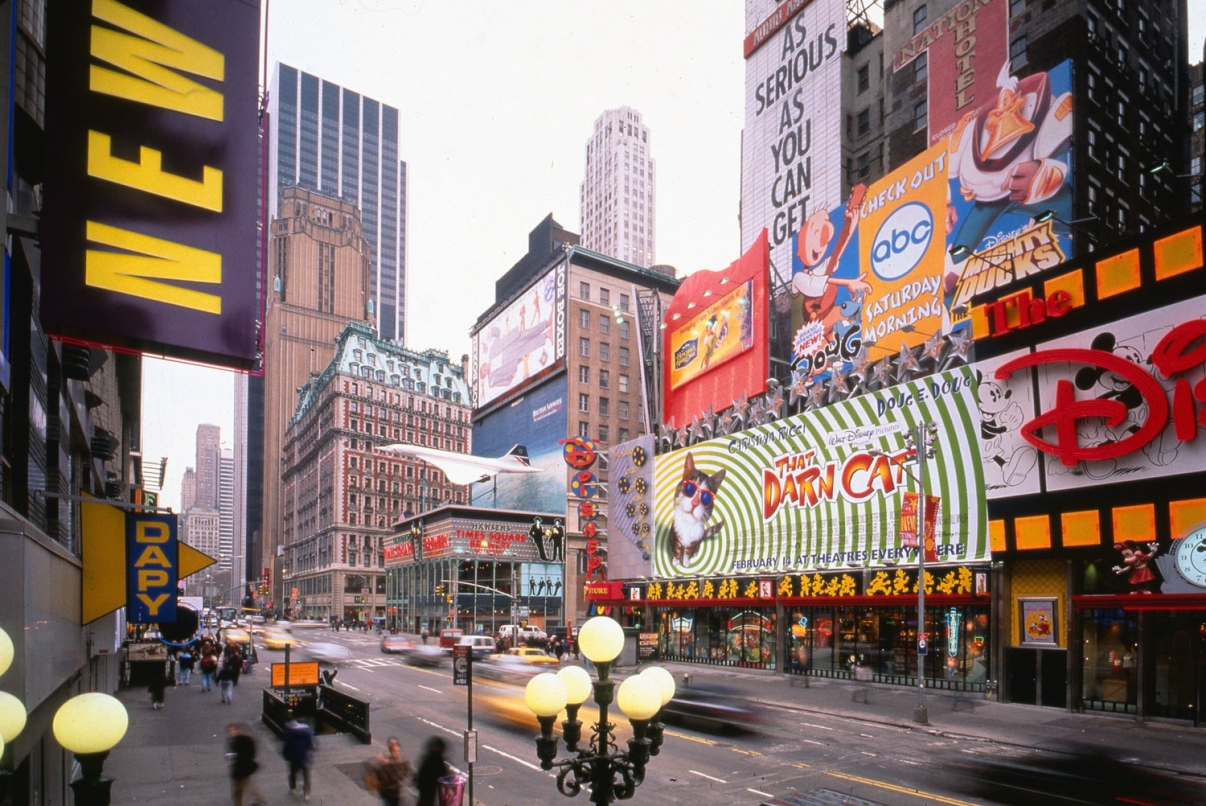 View of 42nd Street looking East in the early 1990s. Before the office towers went up, the street was lined with gig, bright, bold signage, recalling the block’s history, and drawing visitors back to the street.. Credit: Peter Aaron/Otto for Robert A.M. Stern Architects