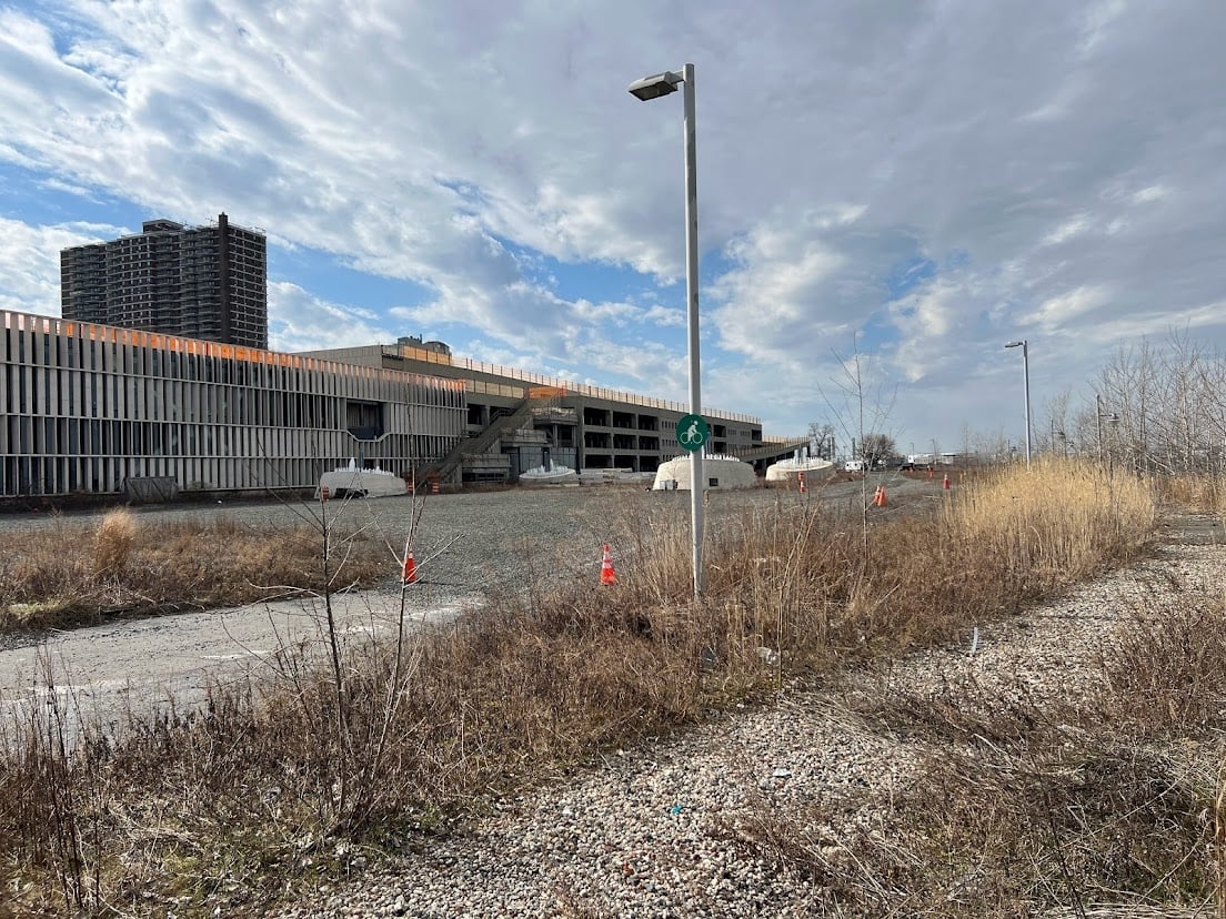 View of St. George Waterfront site in Staten Island. Empty lot with building in the background.