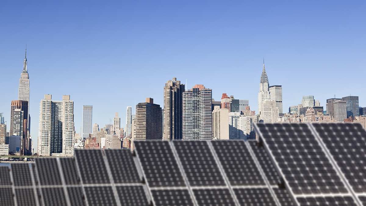 Roof top solar installation with Midtown Manhattan view as background, Chrysler Building and Empire State Building.