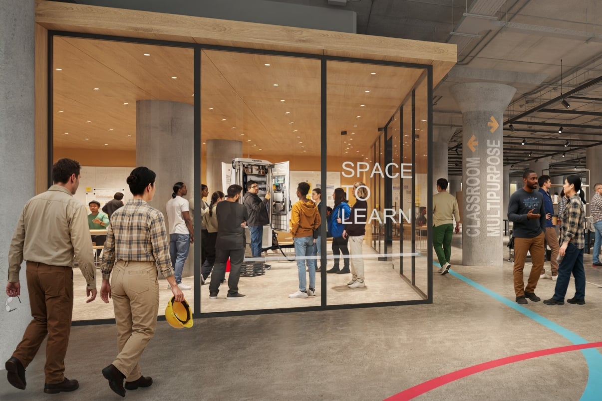BATWorks interior rendering shows people gathering inside and outside a glass-walled room labeled Space to Learn in BATWorks, a modern, industrial-style building. Some walk by, while others interact or observe in the bright, open classroom.