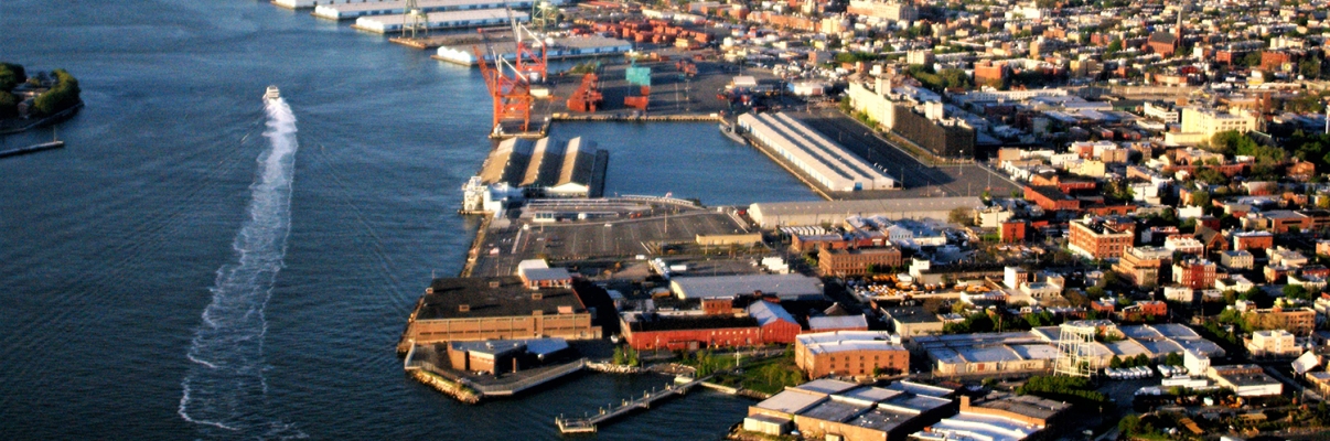 Aerial view of Brooklyn waterfront with Red Hook in foreground and East river in background.