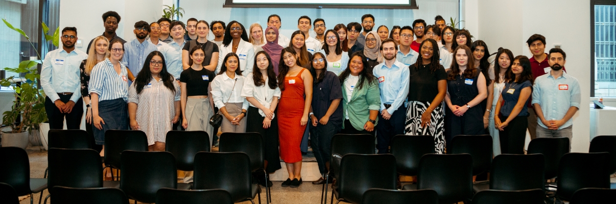 A diverse group of NYC interns pose for a group photo in front of a screen displaying logos for Company Ventures, Blackstone, LaunchPad, NYCEDC, and CIV:LAB. They are in a room with large windows and potted plants.