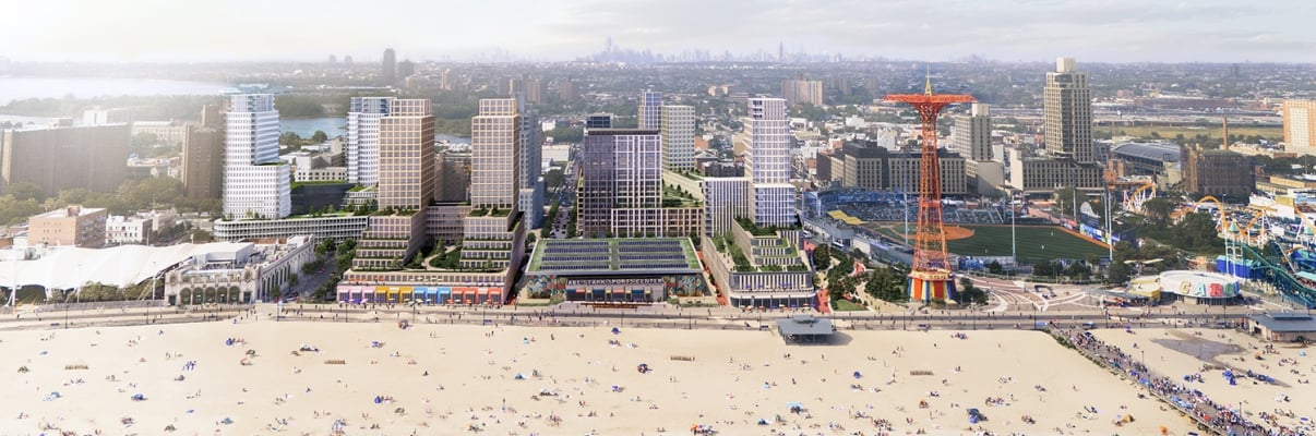 Aerial view of a beach with people, adjacent buildings, and a ferris wheel-like structure in an urban setting.