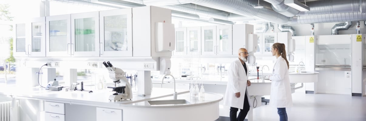 LEAP header shows two scientists in white lab coats stand and talk in a bright, modern laboratory with large windows, lab equipment, and white workstations.